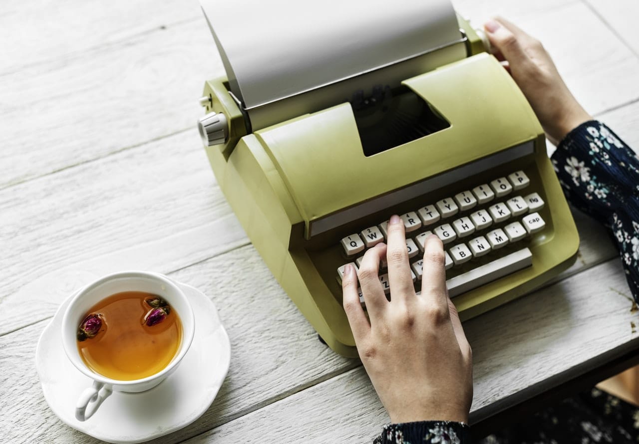 Woman on typewriter with a cup of tea